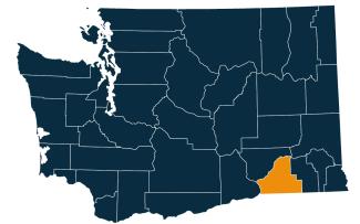 A dark blue map of Washington state with Walla Walla County highlighted in orange.
