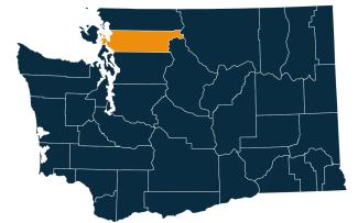 A dark blue map of Washington state with Skagit County highlighted in orange.